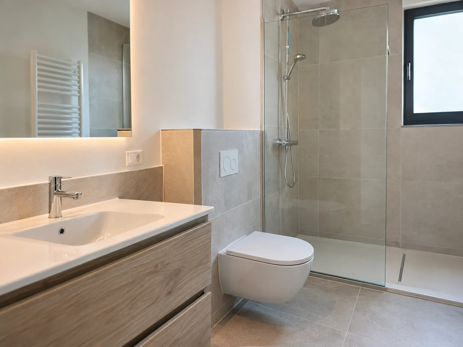 Rénovation d'appartement : salle de bains moderne avec douche, toilettes et vasque